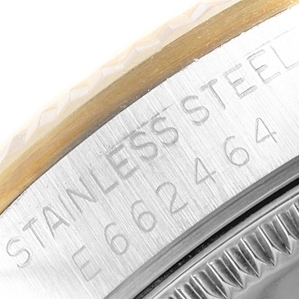 This close-up image of a Mid-Size Rolex watch shows part of the case back with "STAINLESS STEEL" and a serial number engraved.