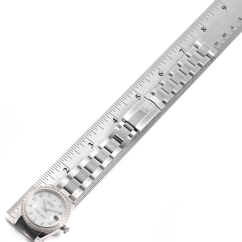 The image shows a Rolex Mid-Size 178384 Women's Stainless Steel Mother of Pearl Dial 178384 Women's Stainless Steel Mother of Pearl Dial watch laid flat with its bracelet and clasp extended alongside a ruler for scale.