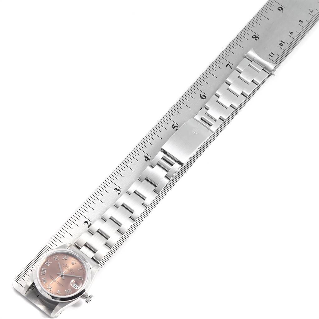 The image shows a Mid-Size Rolex watch face and part of the metal band, aligned next to a measuring ruler.
