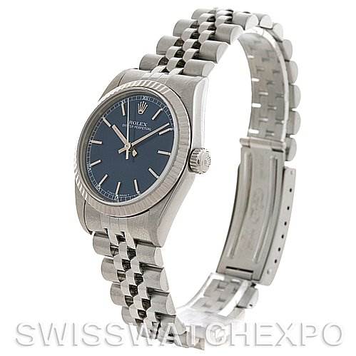 This image shows a Rolex Mid-Size 77014 Women's Stainless Steel Blue Dial 77014 Women's Stainless Steel Blue Dial watch at an angle, highlighting the face, bezel, crown, and partially open bracelet with clasp.