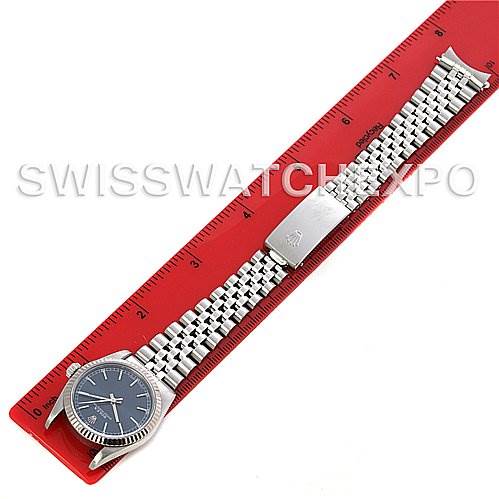 The image shows a Rolex Mid-Size 77014 Women's Stainless Steel Blue Dial 77014 Women's Stainless Steel Blue Dial watch laid flat, displaying the face, bezel, and bracelet against a red ruler for scale.