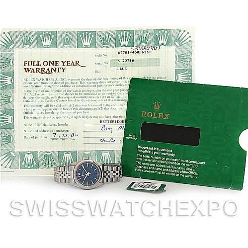 The image shows a Rolex Mid-Size 77014 Women's Stainless Steel Blue Dial 77014 Women's Stainless Steel Blue Dial watch and its accessories, including a warranty card, instruction manual, and original tags.