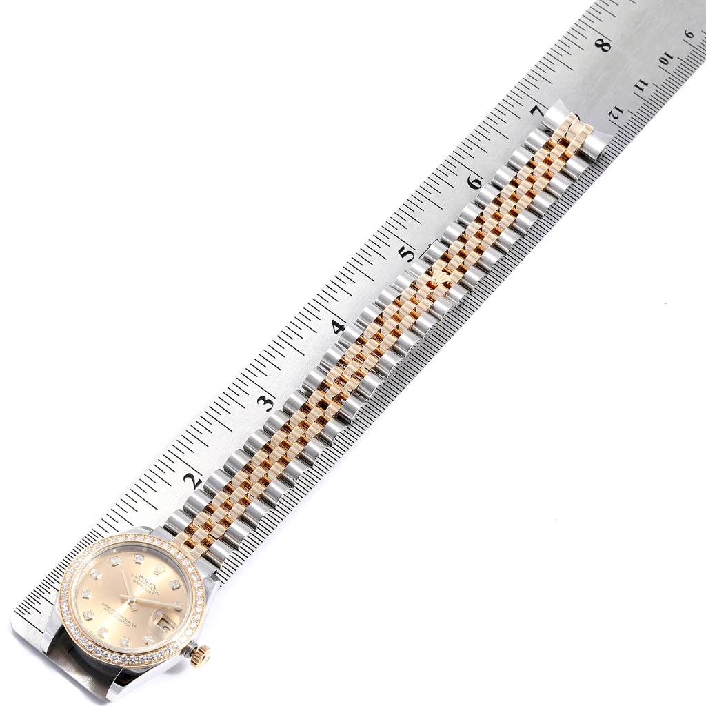 The image shows a Mid-Size Rolex watch with part of its bracelet and dial, measured against a ruler.