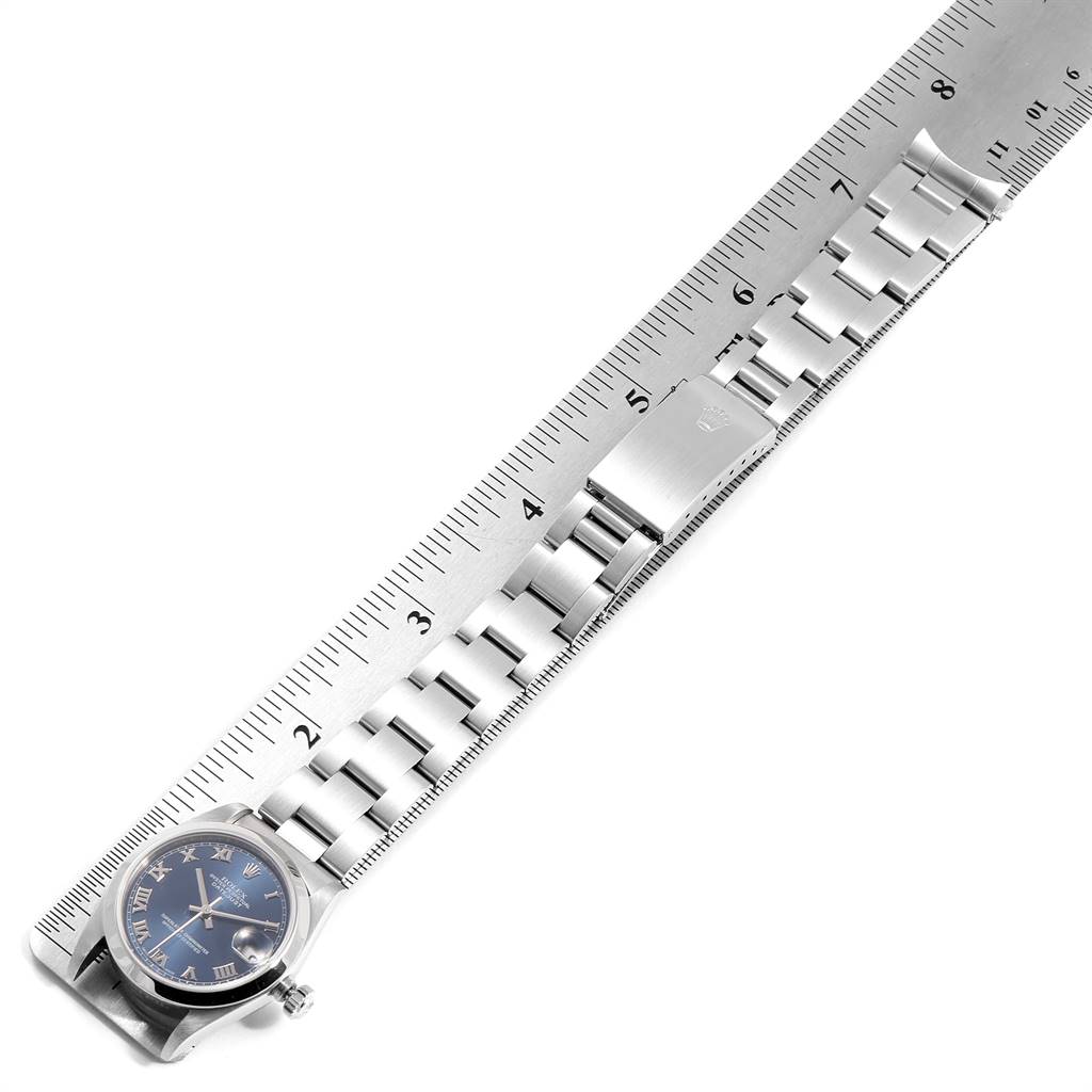 The image shows a Rolex Mid-Size 78240 Women's Stainless Steel Blue Dial 78240 Women's Stainless Steel Blue Dial model watch from an overhead angle, highlighting the face, bracelet, clasp, and a measuring ruler.