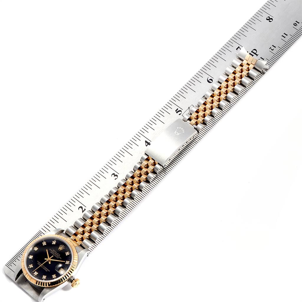 The image shows a Rolex Mid-Size 68273 Women's Steel and Gold (two tone) Black Dial 68273 Women's Steel and Gold (two tone) Black Dial watch laid flat with the dial and bracelet against a ruler.