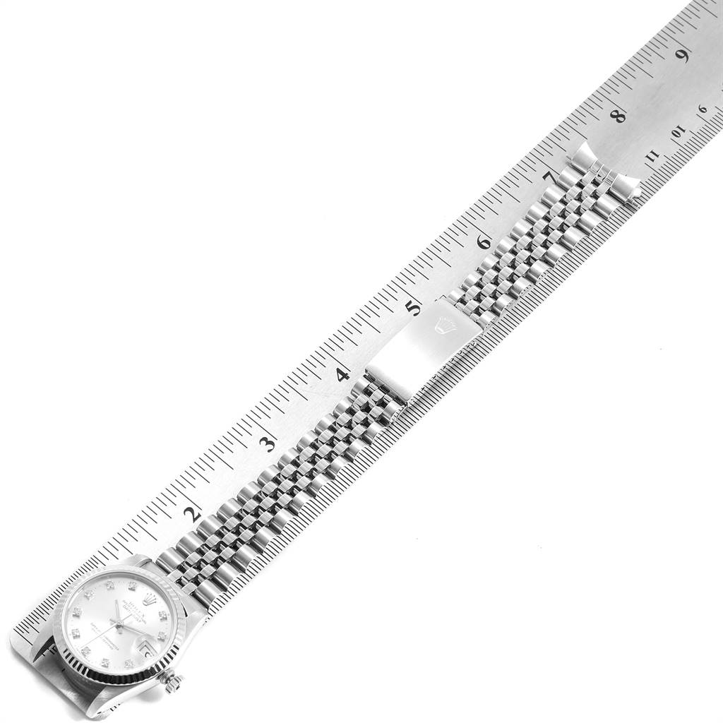 This Rolex Mid-Size 68274 Women's Stainless Steel Silver Dial 68274 Women's Stainless Steel Silver Dial watch is shown at a horizontal angle against a ruler, displaying the face, bracelet, and clasp.