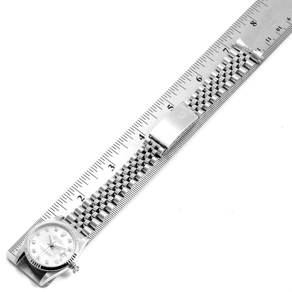 The image shows a Rolex Mid-Size 68274 Women's Stainless Steel Silver Dial 68274 Women's Stainless Steel Silver Dial watch placed diagonally alongside a ruler, displaying its face and metal bracelet.