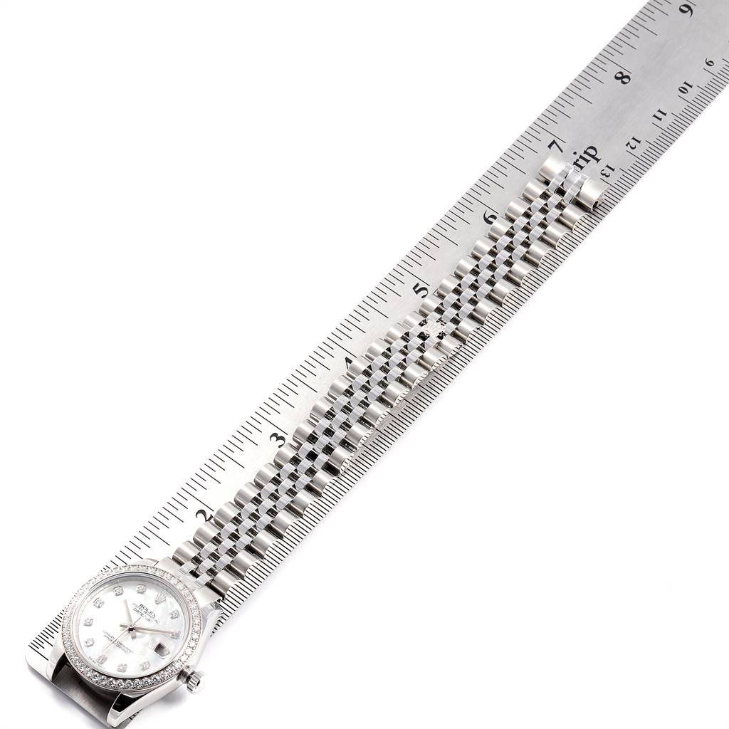 The image shows a bird’s-eye view of a Mid-Size Rolex watch, highlighting the face, bezel, and bracelet next to a ruler.