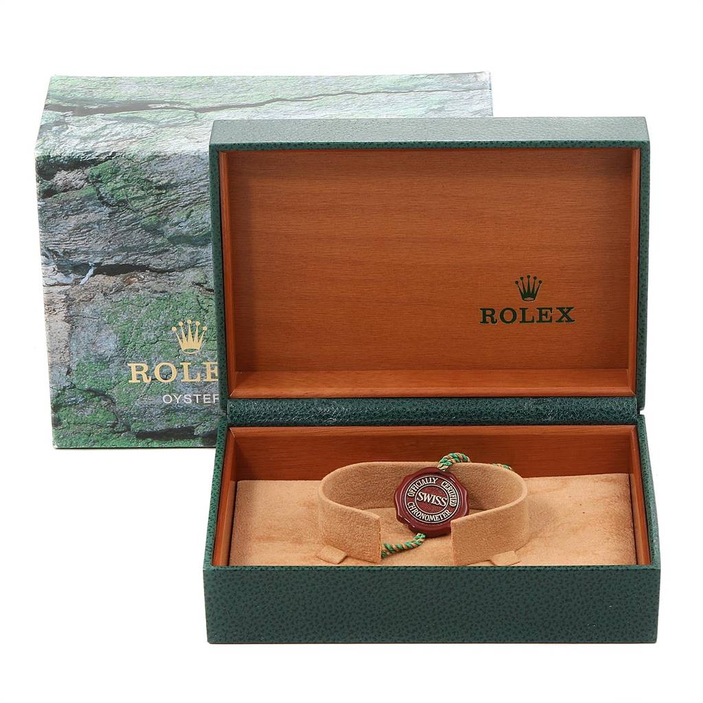The image shows an open Rolex box for a Mid-Size model, displaying a green string tag and a certification seal inside.