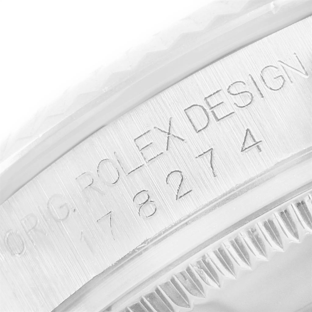 The image shows a close-up of the engraved side of the bezel of a mid-size Rolex watch.
