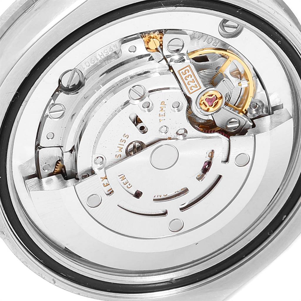 The image shows the movement mechanism of a Mid-Size Rolex watch from a close-up angle, revealing intricate internal components.