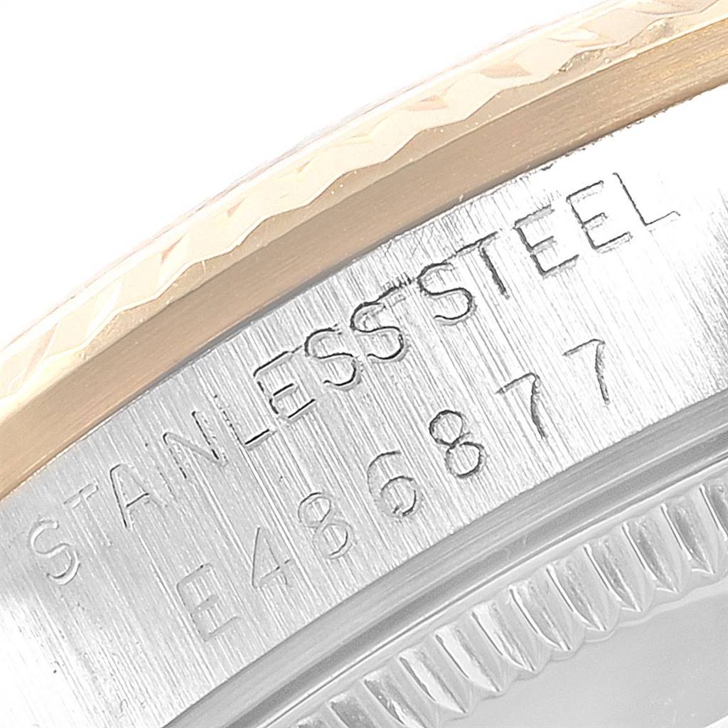 This close-up of a Rolex Mid-Size 68273 Women's Steel and Gold (two tone) Champagne Dial 68273 Women's Steel and Gold (two tone) Champagne Dial watch displays the stainless steel engraving on the case and a part of the fluted bezel.