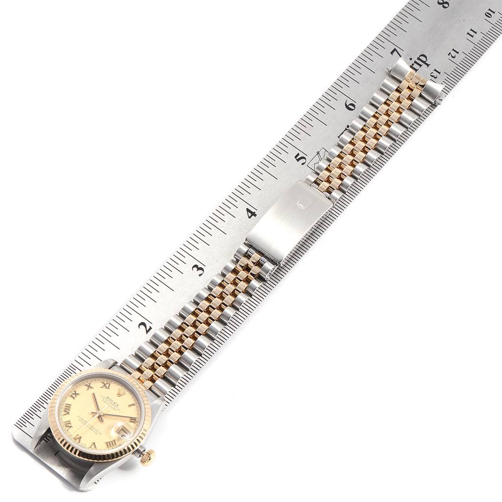The image shows a Rolex Mid-Size 68273 Women's Steel and Gold (two tone) Champagne Dial 68273 Women's Steel and Gold (two tone) Champagne Dial watch from a top view, highlighting the face, bezel, crown, and bracelet alongside a ruler for scale.