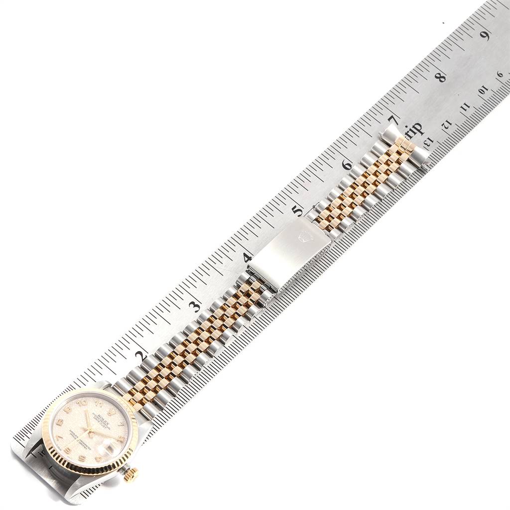 The Rolex Mid-Size 68273 Women's Steel and Gold (two tone) Beige Dial 68273 Women's Steel and Gold (two tone) Beige Dial watch is shown flat, featuring the face, dial, bezel, and metal clasp, placed adjacent to a ruler for size reference.
