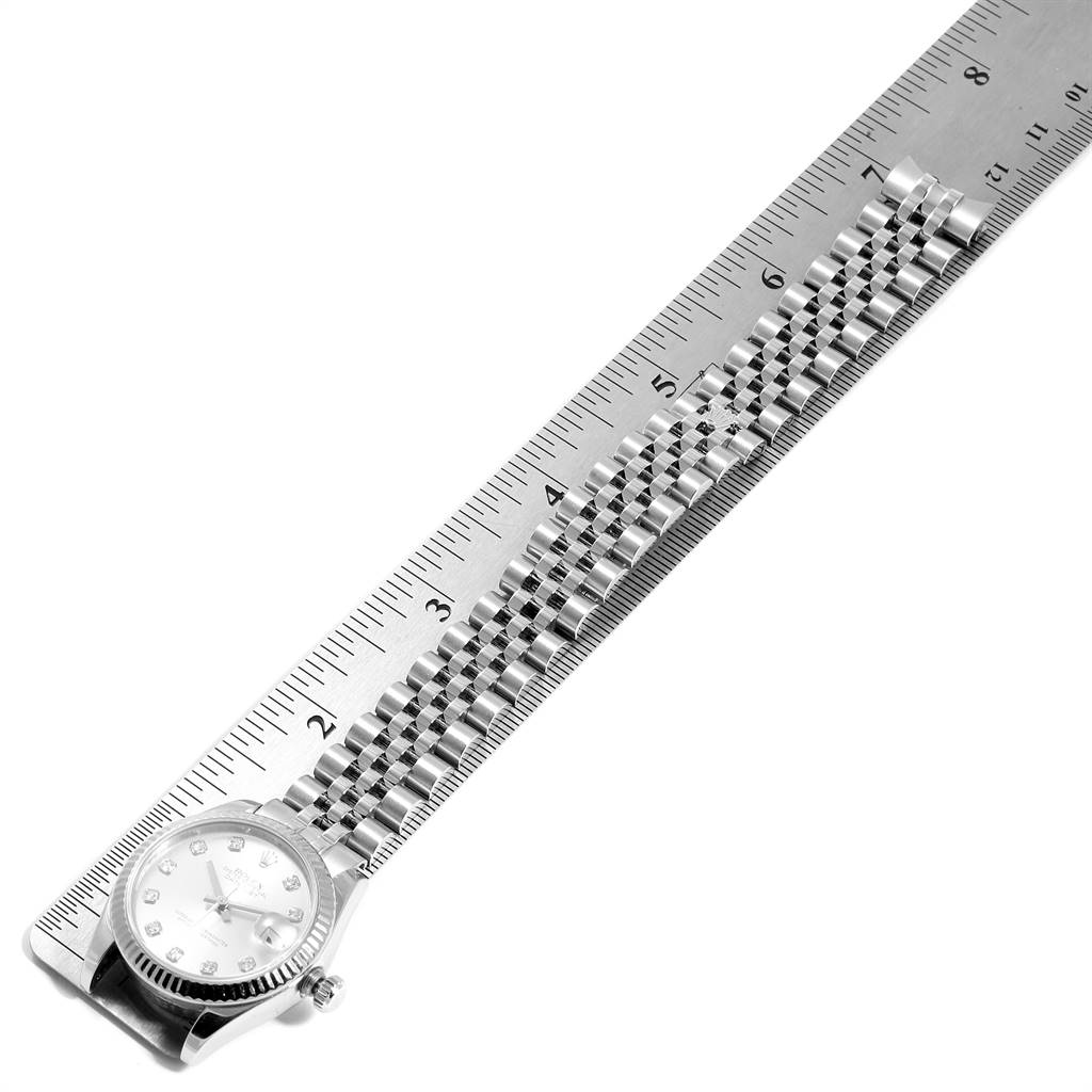 The image shows a Rolex Mid-Size 178274 Women's Stainless Steel Silver Dial 178274 Women's Stainless Steel Silver Dial model watch laid flat, displaying its case, dial, crown, and bracelet alongside a ruler.