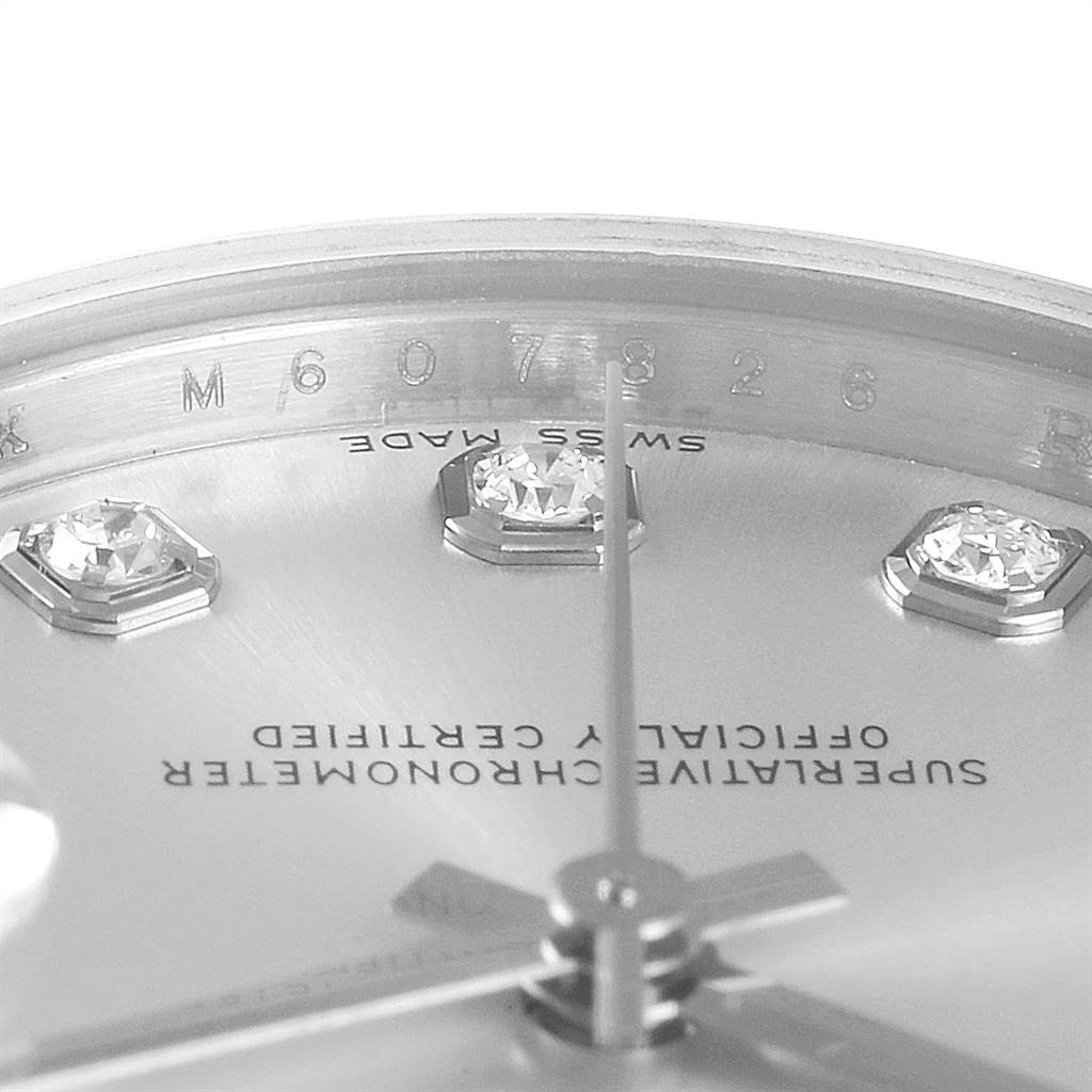 This close-up of a Rolex Mid-Size 178274 Women's Stainless Steel Silver Dial 178274 Women's Stainless Steel Silver Dial watch shows the dial, minute hand, diamond indices, and part of the watch's inner bezel.