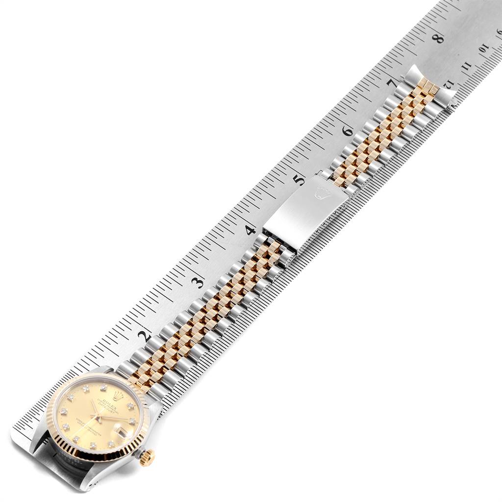 The image shows the front side view of a Rolex Mid-Size 68273 Women's Steel and Gold (two tone) Champagne Dial 68273 Women's Steel and Gold (two tone) Champagne Dial watch with its band laid out against a ruler.