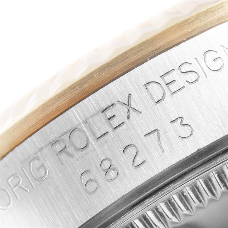 The image shows an angled close-up of the engravings and bezel of a Mid-Size Rolex watch model 68273.