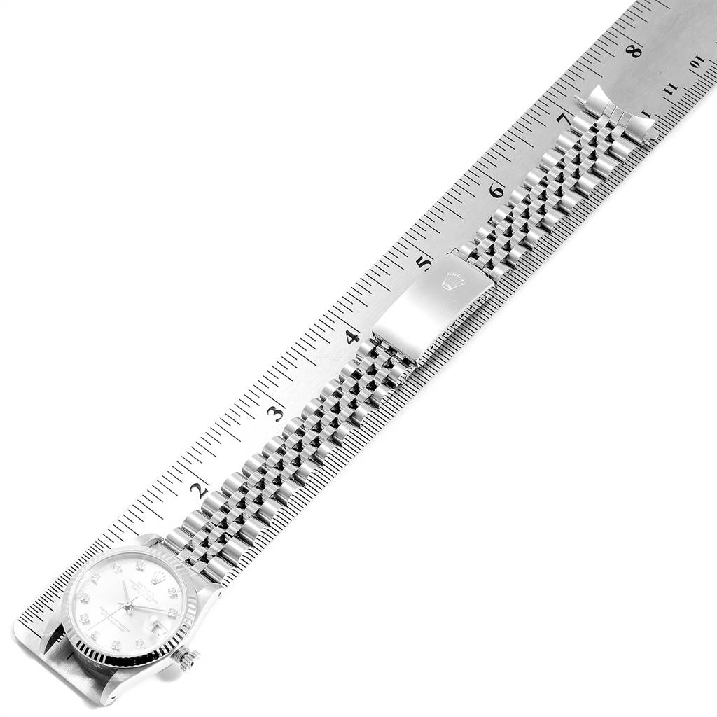 The image shows a Mid-Size Rolex watch, viewed from above, with its silver bracelet and clasp measured against a ruler.