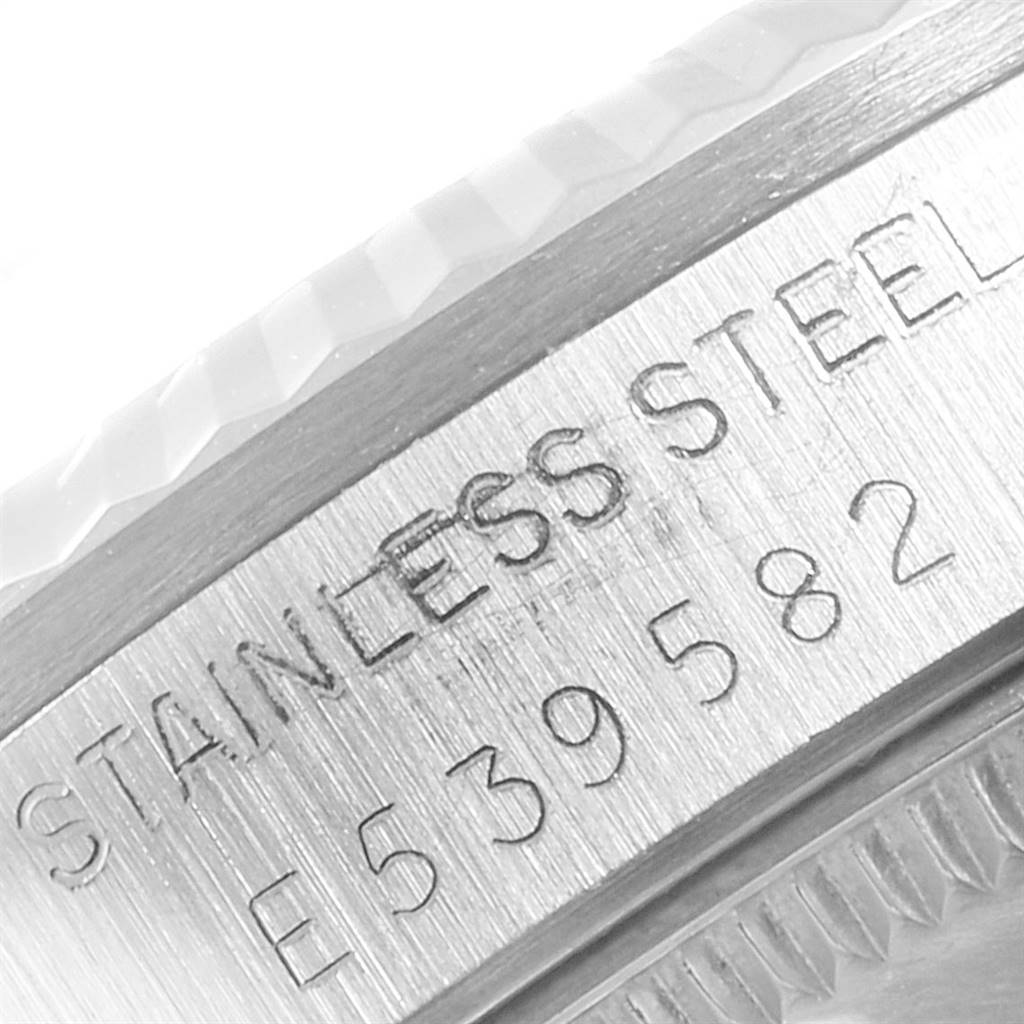 The image shows a close-up of the side of a Rolex Mid-Size 68274 Women's Stainless Steel Silver Dial 68274 Women's Stainless Steel Silver Dial watch, focusing on the "Stainless Steel" engraving and serial number.