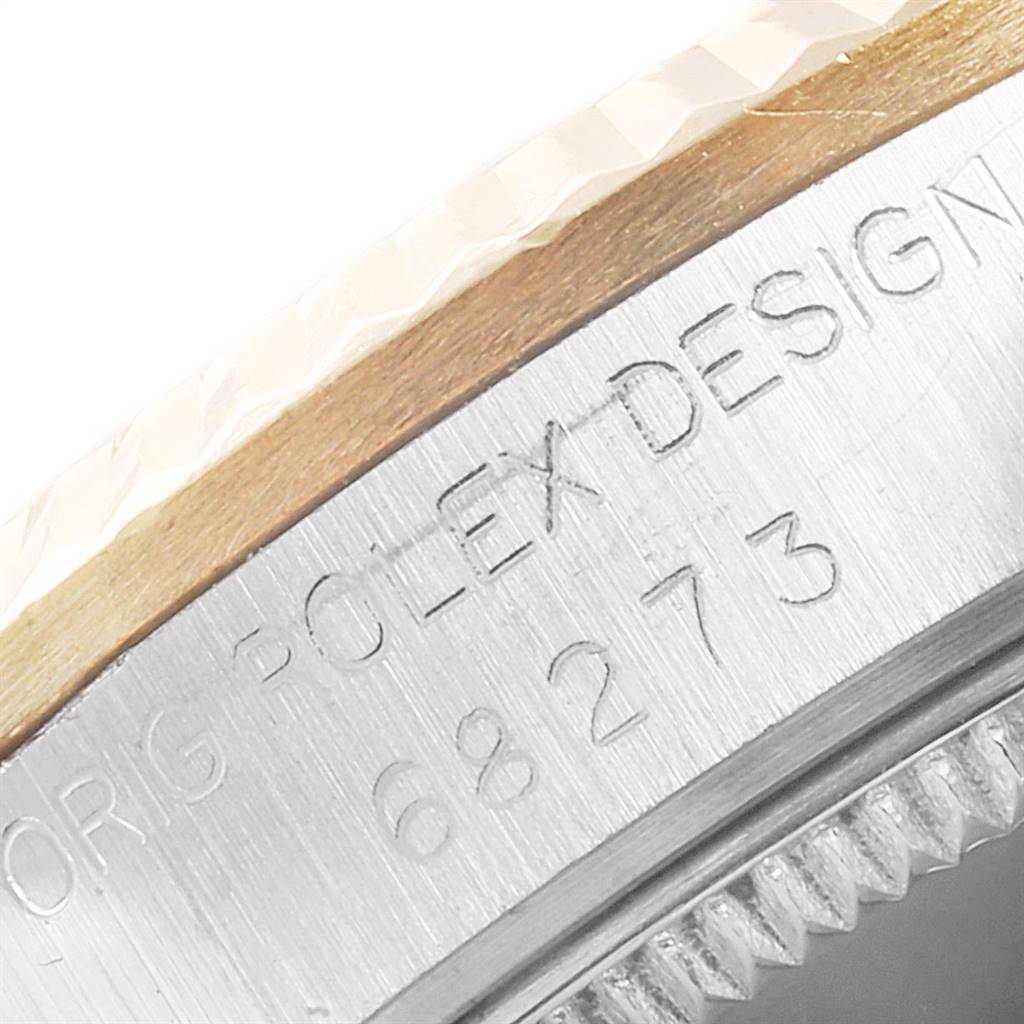 This image shows a close-up of the bezel and part of the case with engraved text on the Mid-Size Rolex watch.