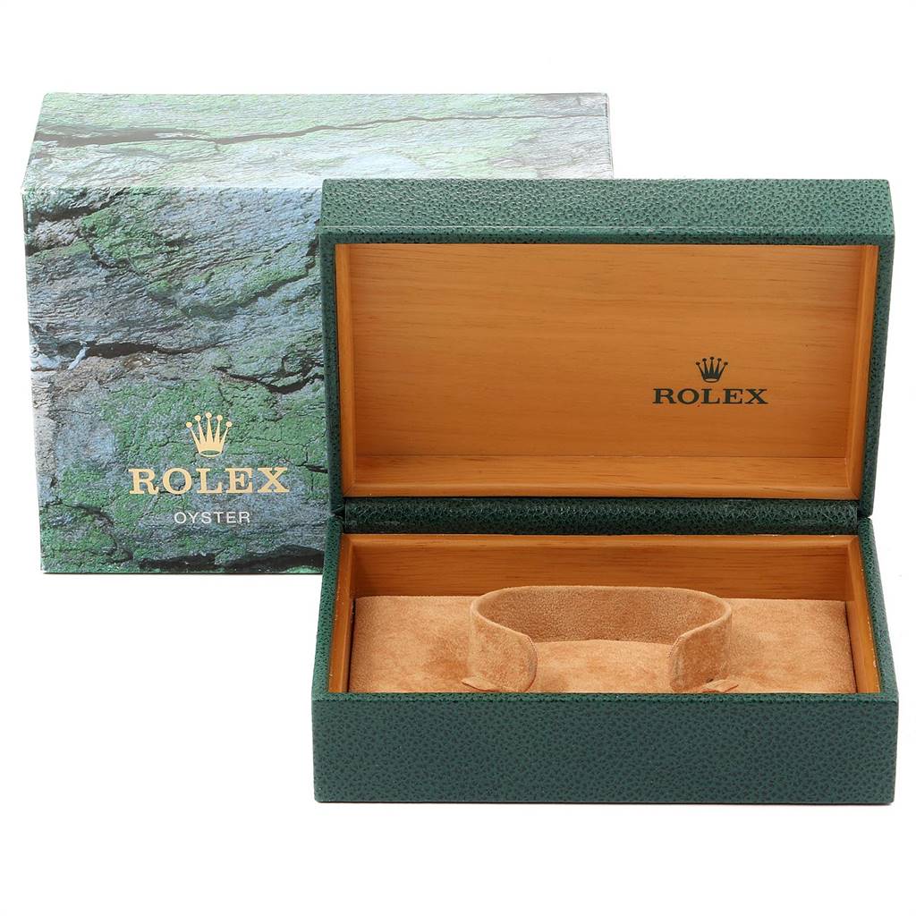 This image shows an open Rolex Oyster watch box, with a green exterior and light brown interior, and its outer packaging.