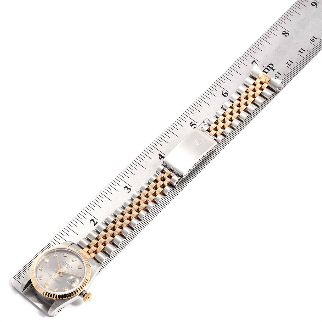 The image shows a Rolex Mid-Size 68273 Women's Steel and Gold (two tone) Silver Dial 68273 Women's Steel and Gold (two tone) Silver Dial watch with a clear view of its face, band, and clasp, placed against a ruler.