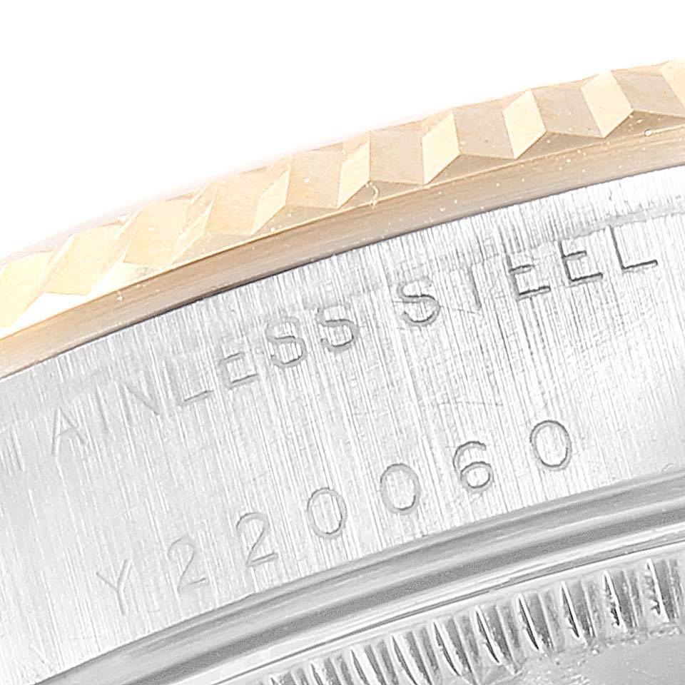 This close-up image of a Rolex Mid-Size 68273 Women's Steel and Gold (two tone) Silver Dial 68273 Women's Steel and Gold (two tone) Silver Dial model shows the stainless steel case and part of the bezel with engraving details.