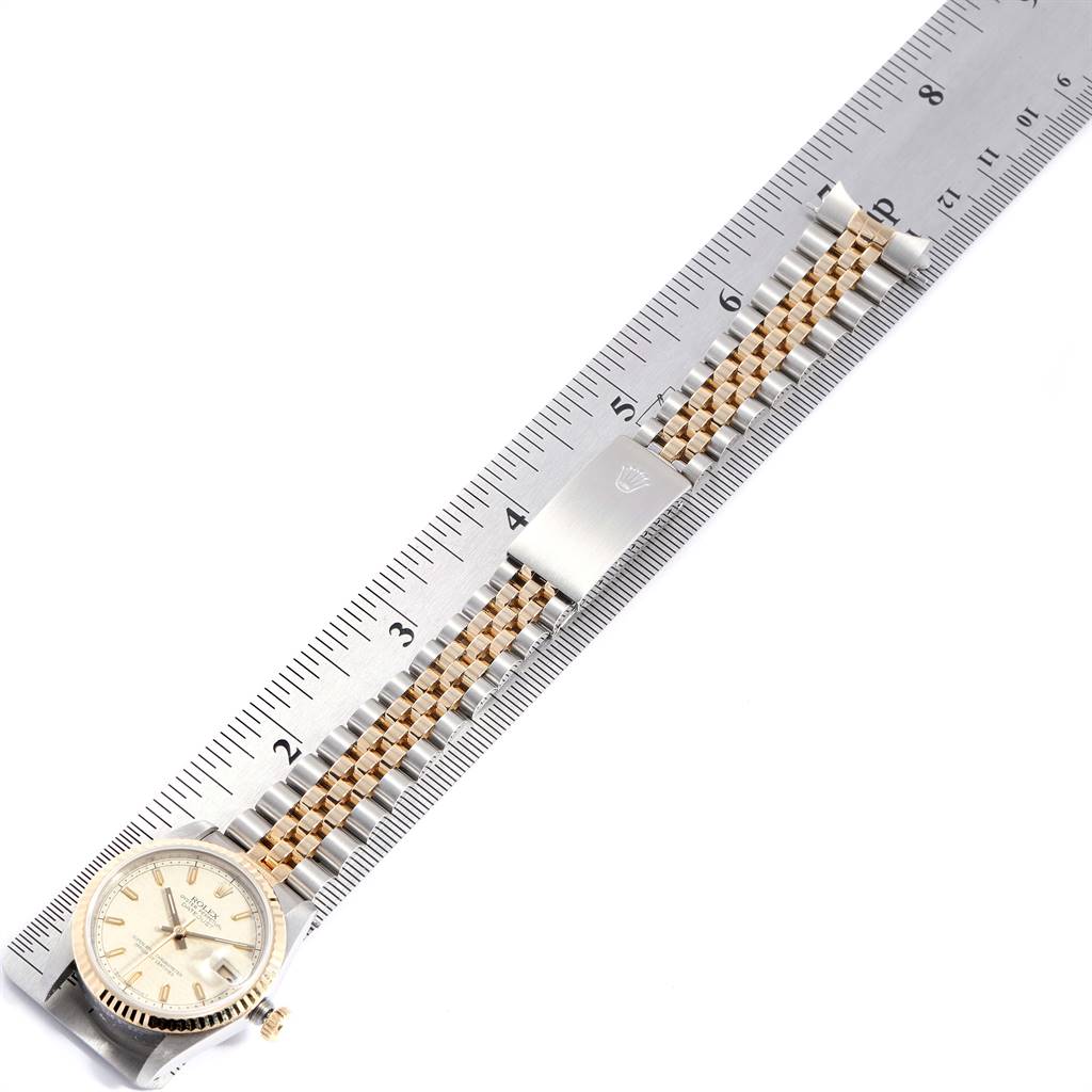 The image shows a Rolex Mid-Size 68273 Women's Steel and Gold (two tone) Beige Dial 68273 Women's Steel and Gold (two tone) Beige Dial watch placed alongside a ruler, highlighting the bracelet and clasp.