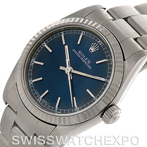 The image shows a Rolex Mid-Size 77014 Women's Stainless Steel Blue Dial 77014 Women's Stainless Steel Blue Dial Oyster Perpetual watch at an angle that highlights the dial, bezel, crown, and bracelet.