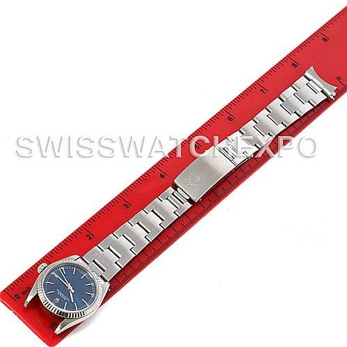 The image shows a Mid-Size Rolex watch, laid flat with its bracelet extended, alongside a red ruler for scale.