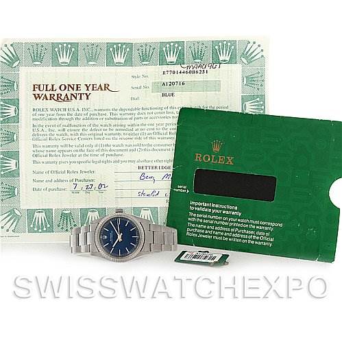 The image shows a Rolex Mid-Size 77014 Women's Stainless Steel Blue Dial 77014 Women's Stainless Steel Blue Dial watch displayed flat along with its warranty card and instruction booklet, seen from a top-down angle.