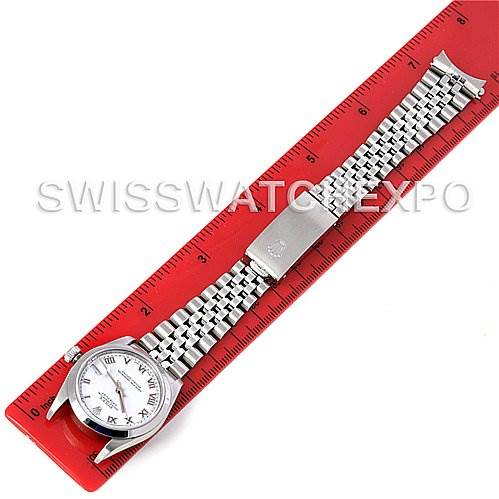 This image shows a Rolex Mid-Size 78240 Women's Stainless Steel White Dial 78240 Women's Stainless Steel White Dial model watch laid flat next to a ruler, displaying its face, bracelet, and clasp.