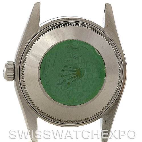 This image shows the back case of a Mid-Size Rolex watch, displaying the crown and case back with an intact green sticker.