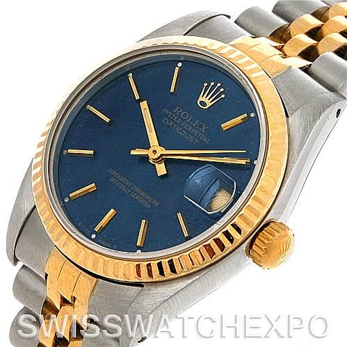 The image shows a Mid-Size Rolex watch at a slight angle, highlighting its blue dial, gold bezel, two-tone bracelet, and date display.