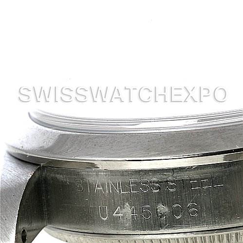 The image shows a close-up angle of the case back and lugs of a mid-size Rolex watch, with "Stainless Steel" and a serial number engraved.