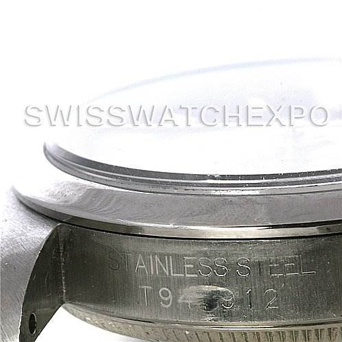 The image shows a close-up of the side and bezel of a mid-size Rolex watch, highlighting the "Stainless Steel" engraving.