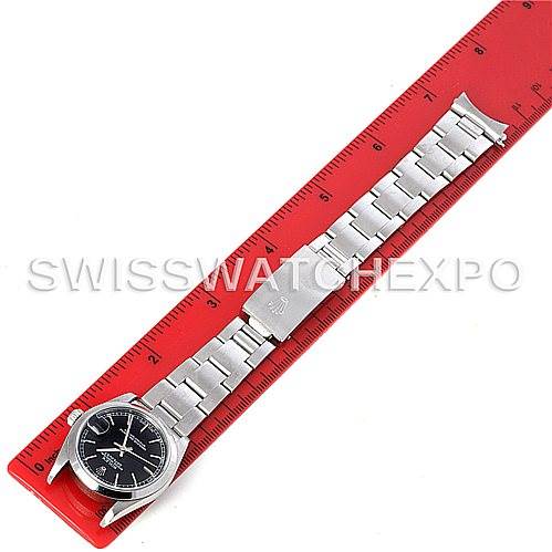 The image shows the Rolex Mid-Size 78240 Women's Stainless Steel Black Dial 78240 Women's Stainless Steel Black Dial model watch laid flat against a ruler, displaying the face, bracelet, and clasp.