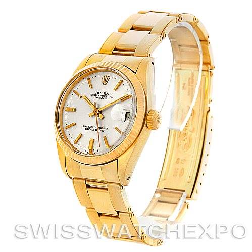 The image shows a Rolex Mid-Size 6827 Women's Yellow Gold Silver Dial 6827 Women's Yellow Gold Silver Dial model watch at an angled view, detailing its gold bracelet, white dial, and date display.