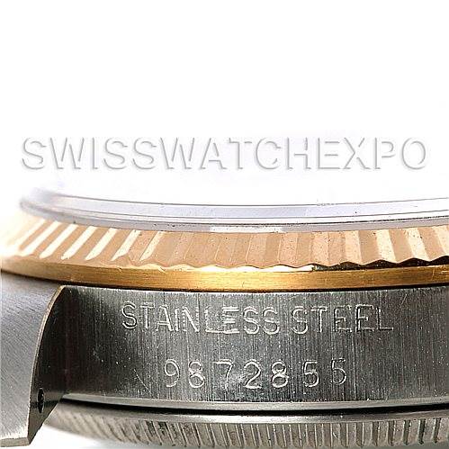 The image shows a close-up side view of the stainless steel case and bezel of a Mid-Size Rolex watch, including part of its serial number.