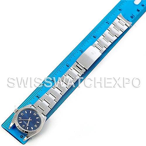 This image shows a top-down view of a Rolex Mid-Size 67514 Women's Stainless Steel Blue Dial 67514 Women's Stainless Steel Blue Dial watch placed next to a blue ruler for scale.