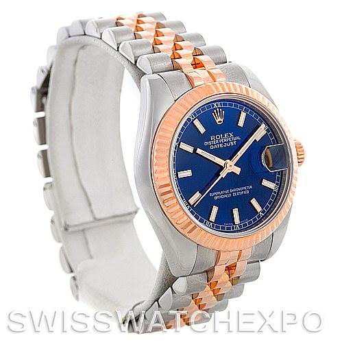 The image shows a Rolex Datejust Mid-Size model from a three-quarter angle, highlighting the blue dial, two-tone bracelet, and fluted bezel.