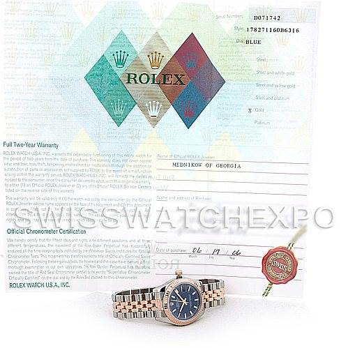 The image shows a Rolex Mid-Size 178271 Women's Steel and Gold (two tone) Blue Dial 178271 Women's Steel and Gold (two tone) Blue Dial watch with its certification and an accessory tag, viewed from a front angle.