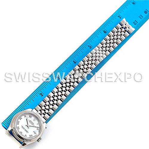 This image shows a bird
s eye view of a Rolex Mid-Size 178274 Women
s Stainless Steel White Dial 178274 Women
s Stainless Steel White Dial watch with its face and bracelet laid beside a ruler for measurement.