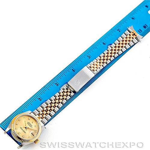 The image shows a Rolex Mid-Size 68273 Women's Stainless Steel Champagne Dial 68273 Women's Stainless Steel Champagne Dial watch laid out flat with a blue ruler for scale, displaying its face and band.