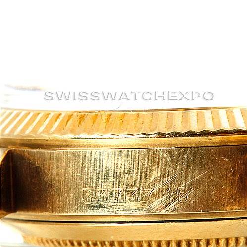 This close-up image shows the side of the case, bezel, and engraved serial number of a Rolex Mid-Size 6827 Women's Yellow Gold Silver Dial 6827 Women's Yellow Gold Silver Dial model watch.