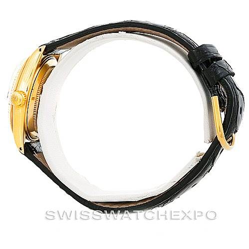 This image shows the side view of a Rolex Mid-Size 6827 Women's Yellow Gold Silver Dial 6827 Women's Yellow Gold Silver Dial watch, displaying the case, crown, bezel, and black strap.