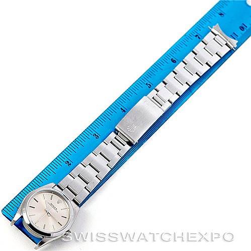The Rolex Mid-Size 67480 Women's Stainless Steel Silver Dial 67480 Women's Stainless Steel Silver Dial model watch is shown laid flat, with its bracelet fully extended next to a blue ruler for size reference.