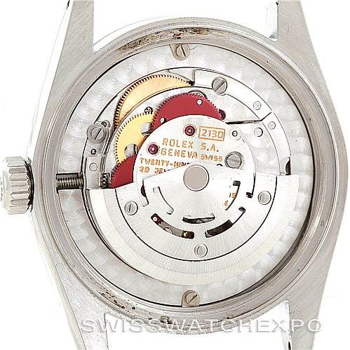 The image shows the back view of a Mid-Size Rolex watch, revealing its open movement and internal mechanical parts.