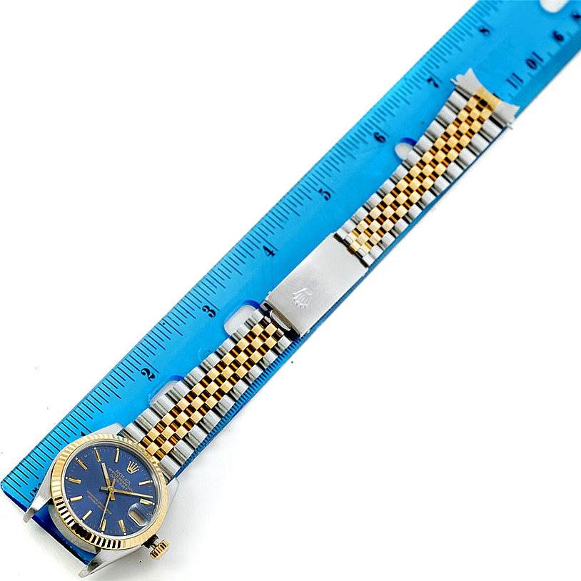 The image shows a full frontal view of a Rolex Mid-Size 68273 Women's Stainless Steel Blue Dial 68273 Women's Stainless Steel Blue Dial watch with a blue dial and two-tone bracelet next to a ruler.